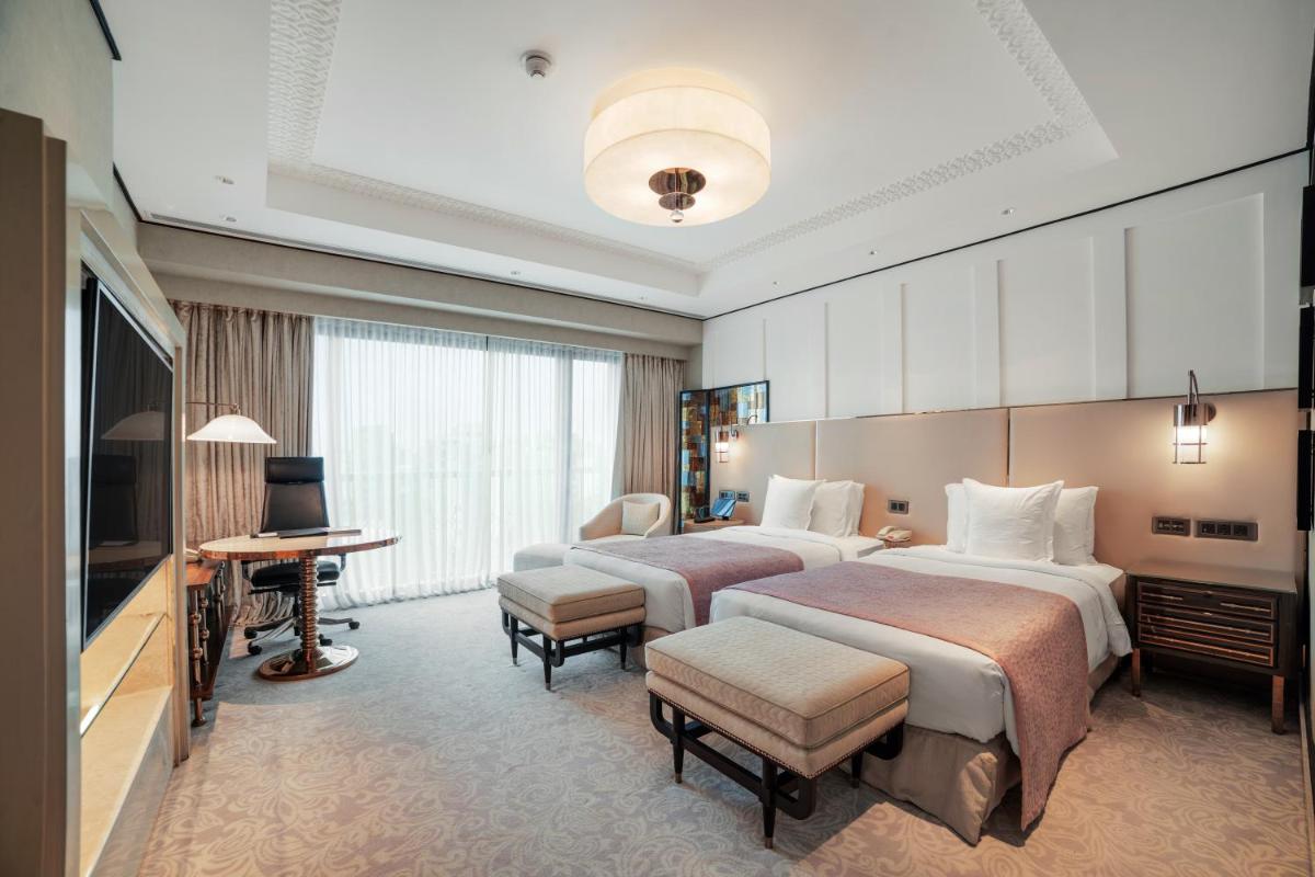 a hotel room with two beds and a television at ITC Narmada, a Luxury Collection Hotel, Ahmedabad in Ahmedabad