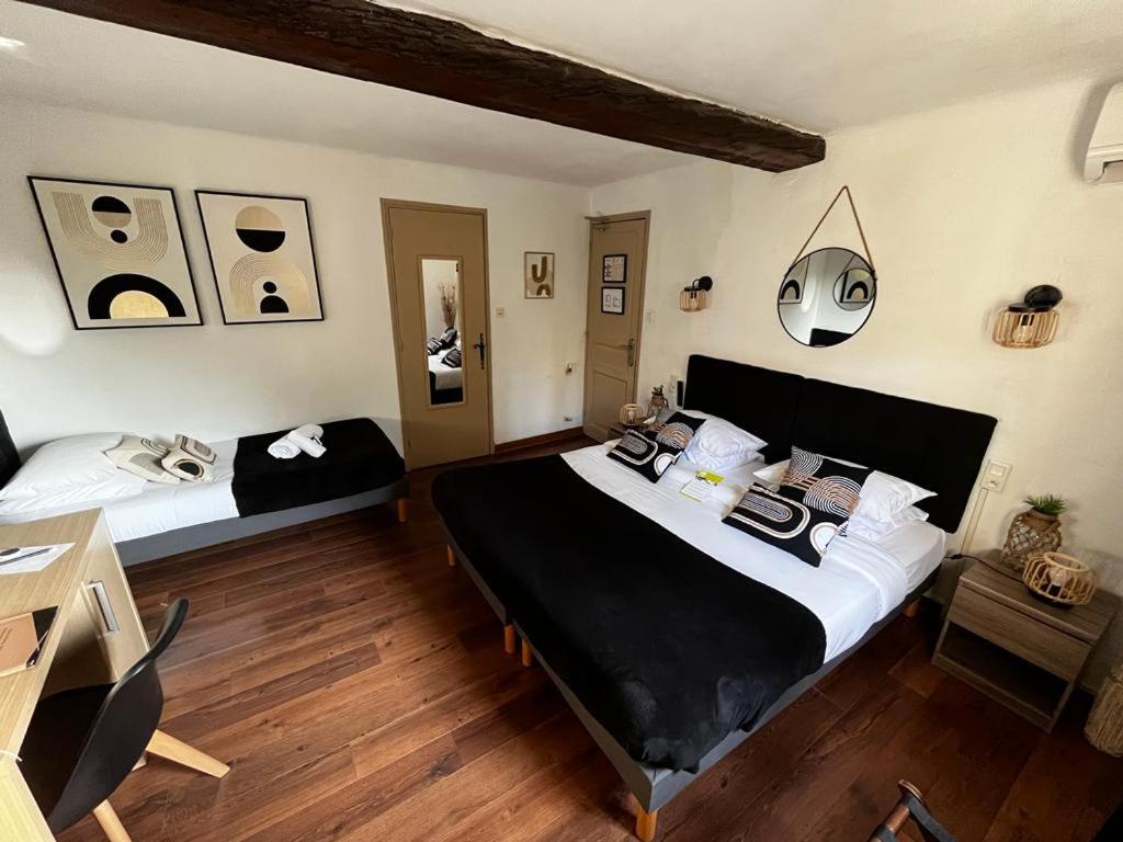 une chambre avec deux lits et un bureau dans l'établissement Le Château d'Argens, aux Arcs-sur-Argens