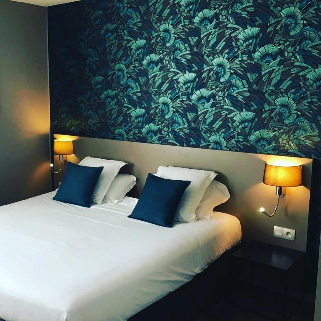 Un ou plusieurs lits dans un hébergement de l'établissement Brit Hotel Le Galion & Spa