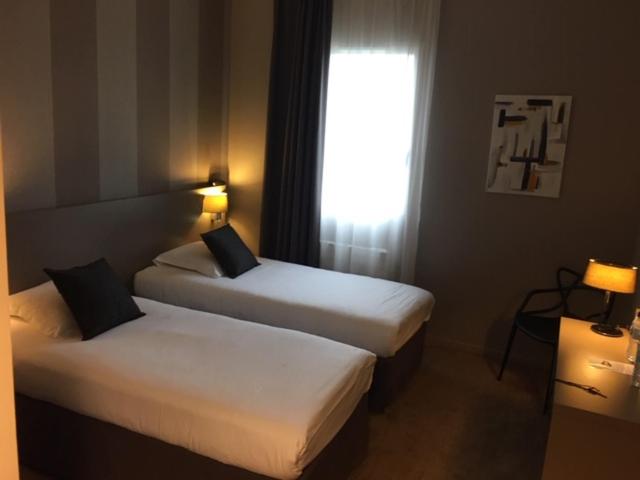 Un ou plusieurs lits dans un hébergement de l'établissement Brit Hotel Le Galion & Spa