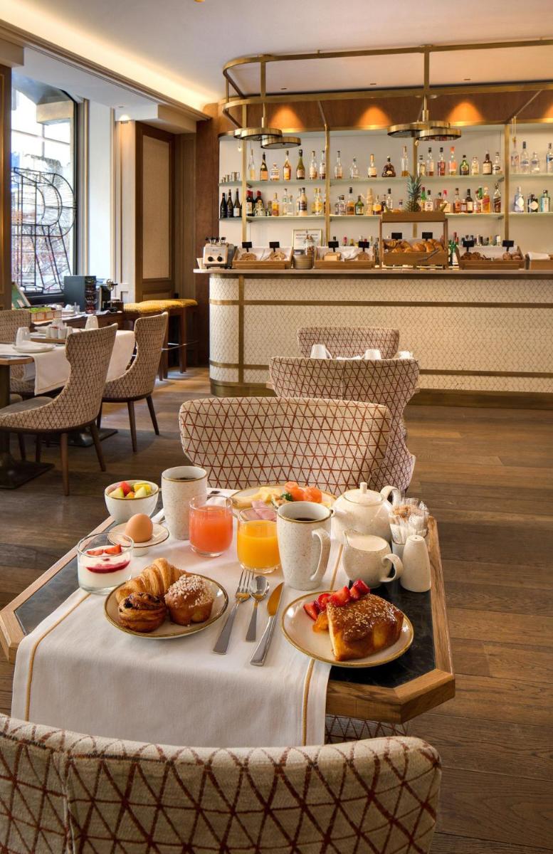 une table avec des aliments pour le petit-déjeuner dans un restaurant dans l'établissement Rochester Champs Elysees, à Paris