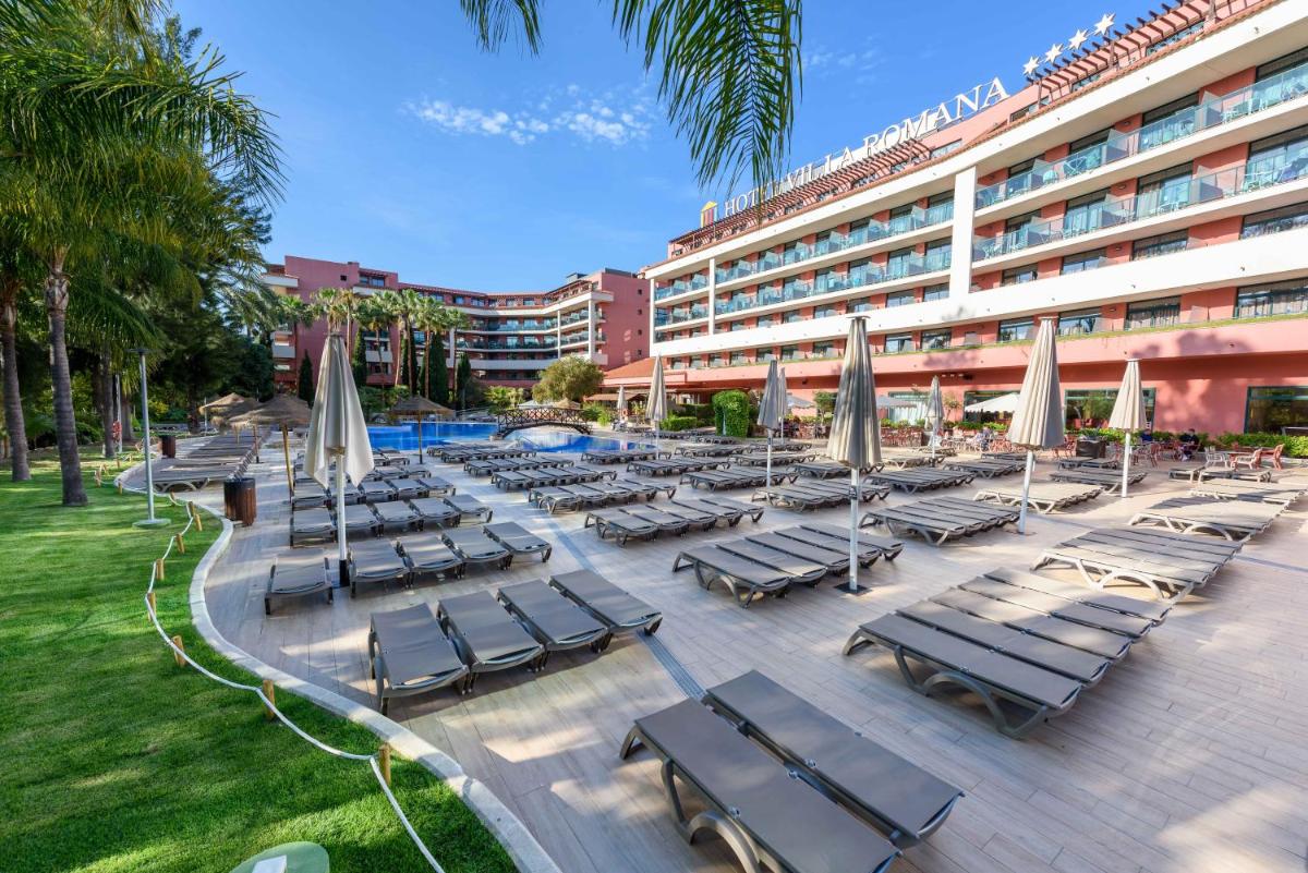 un grupo de tumbonas y sombrillas frente a un hotel en Ohtels Vil·la Romana, en Salou