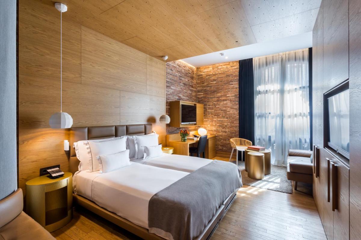 Una habitación de hotel con una cama grande y un escritorio. en Monument Hotel, en Barcelona