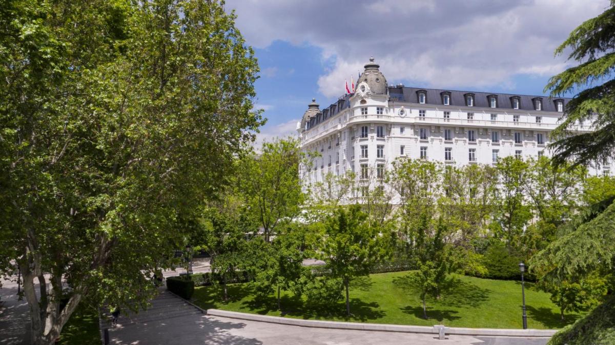 Un gran edificio blanco con árboles delante. en Mandarin Oriental Ritz, Madrid, en Madrid
