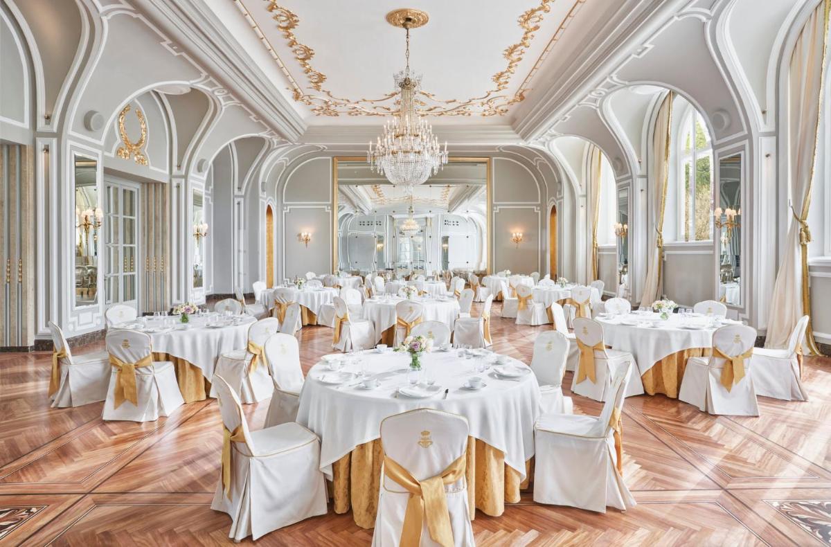 un salón de baile con mesas y sillas blancas y una lámpara de araña en Mandarin Oriental Ritz, Madrid, en Madrid 79 fotos más
