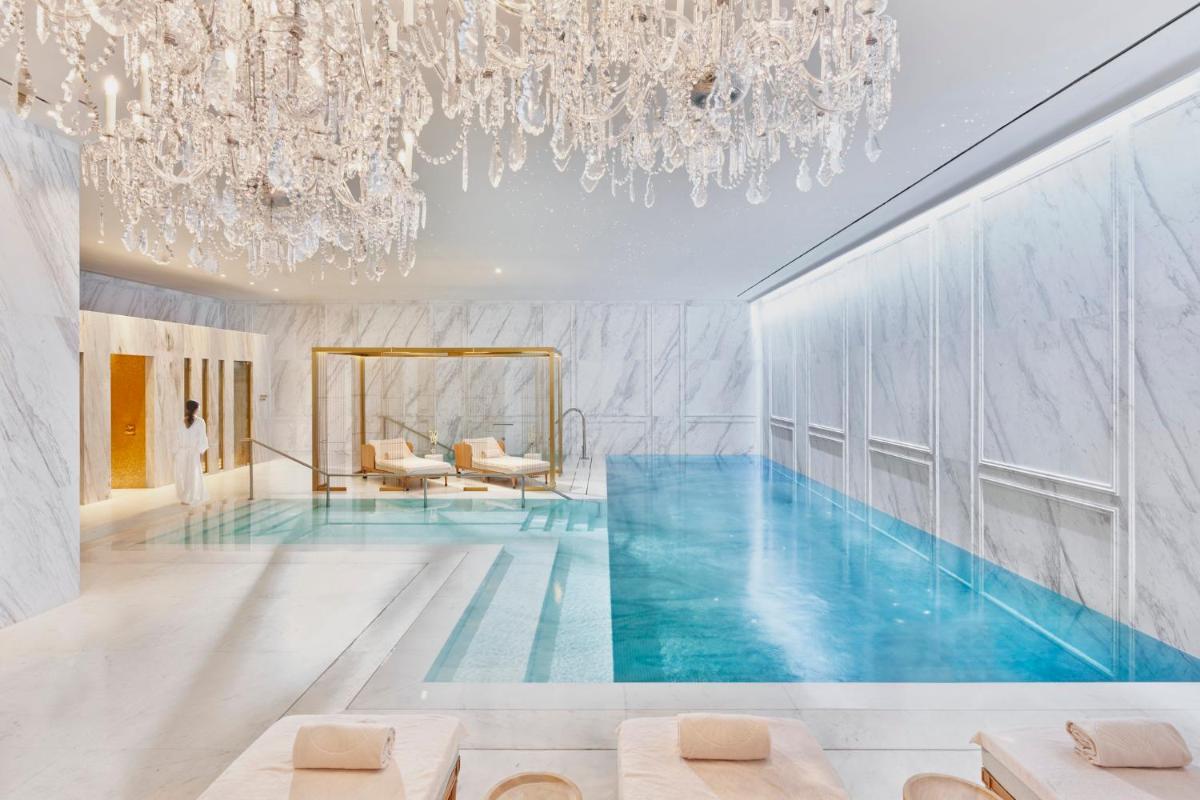 una piscina en una habitación con una lámpara de araña en Mandarin Oriental Ritz, Madrid, en Madrid