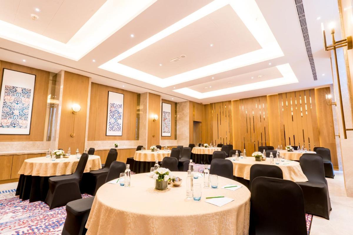 a conference room with tables and chairs and a ceiling at Holiday Inn Lucknow Airport by IHG in Lucknow