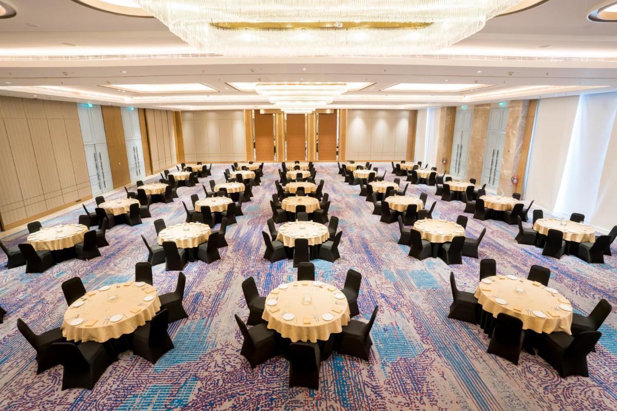 a banquet hall with tables and chairs in a room at Holiday Inn Lucknow Airport by IHG in Lucknow