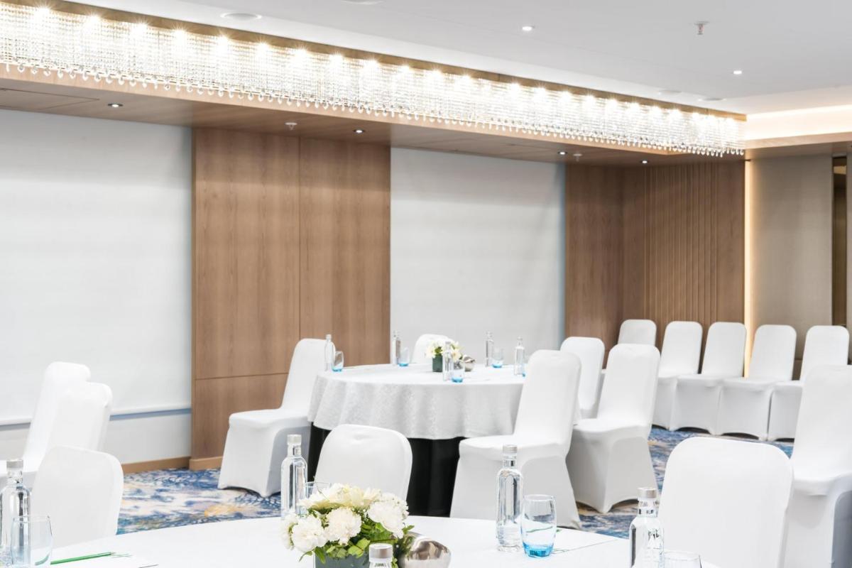a conference room with a table and white chairs at Holiday Inn Lucknow Airport by IHG in Lucknow
