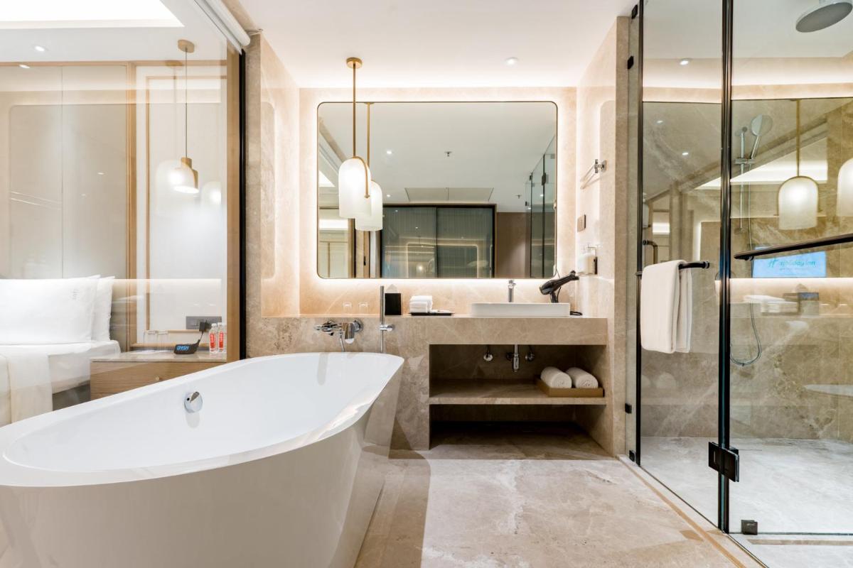 a bathroom with a tub and a sink and a mirror at Holiday Inn Lucknow Airport by IHG in Lucknow