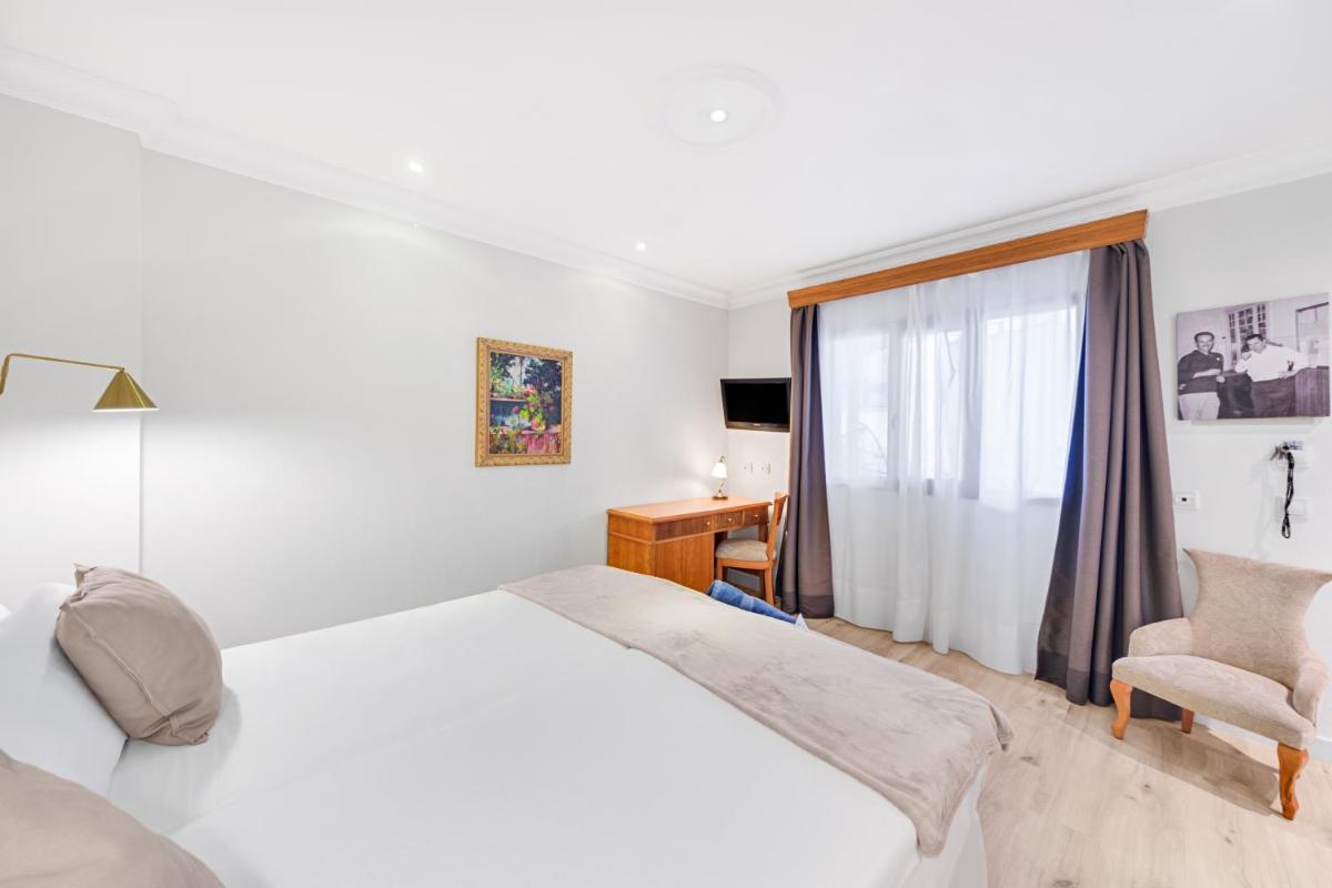 Cama o camas de una habitación en Hotel Ciutat Jardi