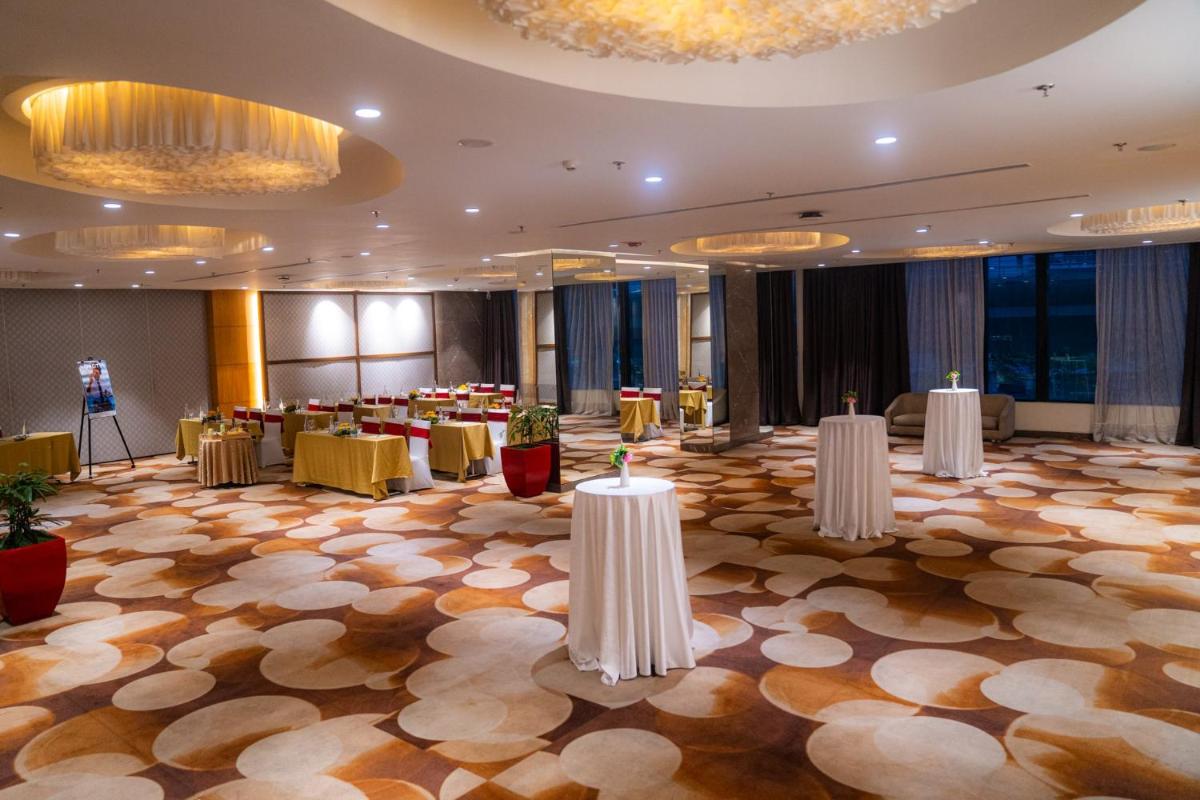 a banquet hall with tables and chairs in a room at Novotel Kolkata Hotel and Residences in Kolkata a banquet hall with tables and chairs in a room at Novotel Kolkata Hotel and Residences in Kolkata