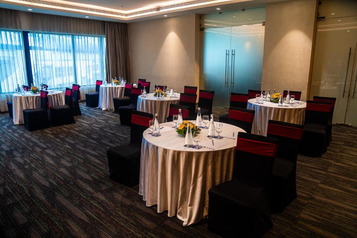 a conference room with tables and chairs and tablesktop at Novotel Kolkata Hotel and Residences in Kolkata a conference room with tables and chairs and tablesktop at Novotel Kolkata Hotel and Residences in Kolkata