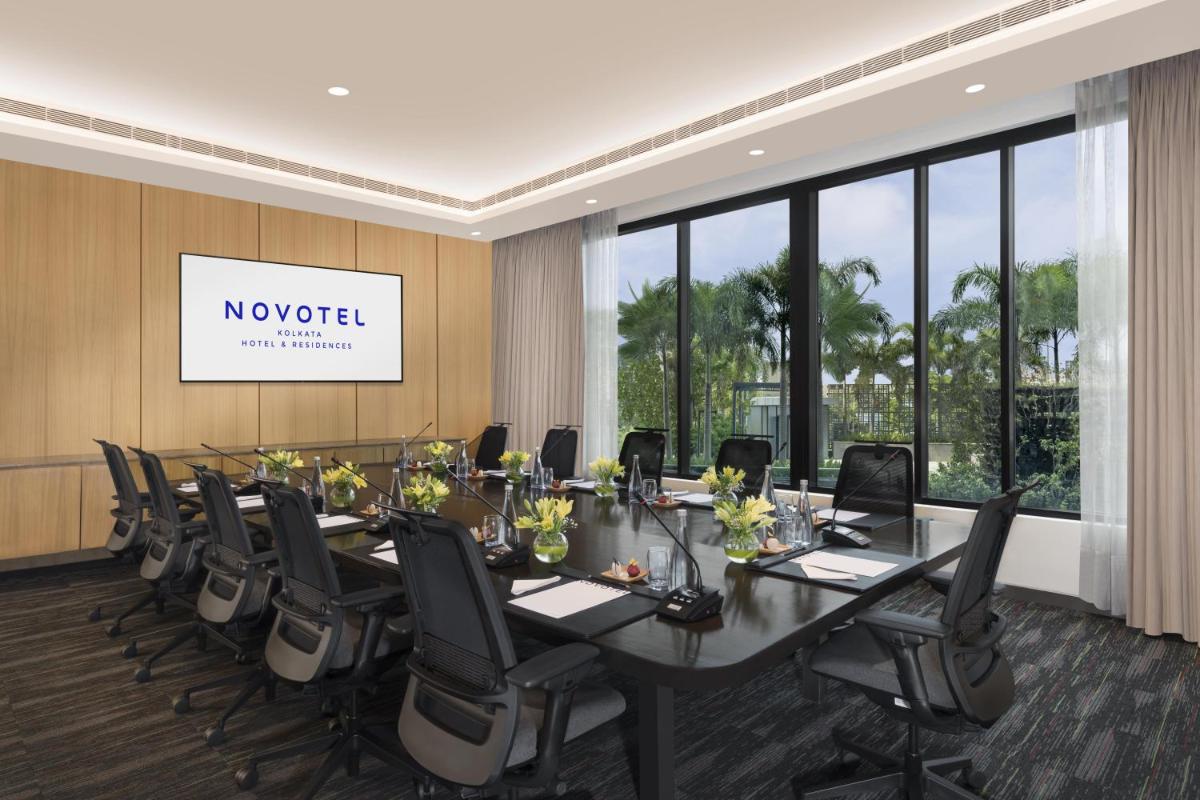 a conference room with a long table and chairs at Novotel Kolkata Hotel and Residences in Kolkata a conference room with a long table and chairs at Novotel Kolkata Hotel and Residences in Kolkata