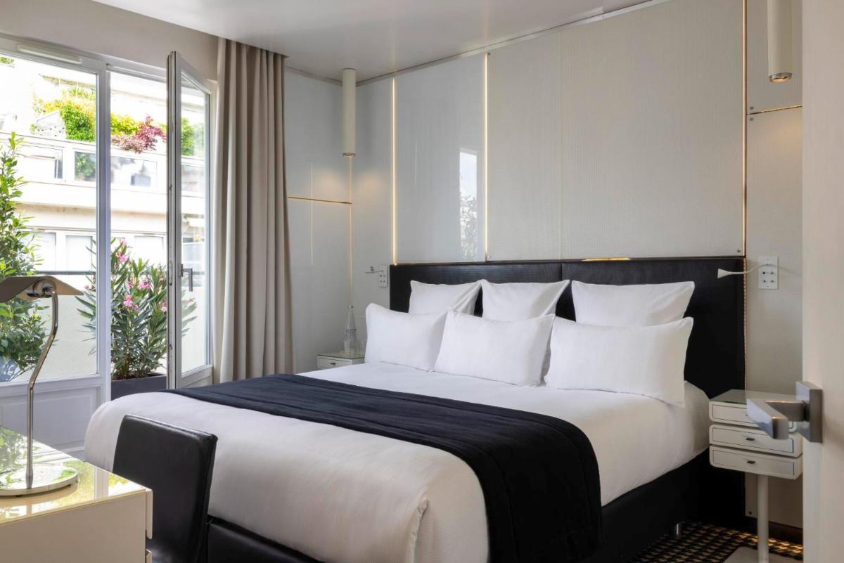 une chambre avec un grand lit avec des oreillers blancs dans l'établissement Hôtel Félicien & Spa, à Paris