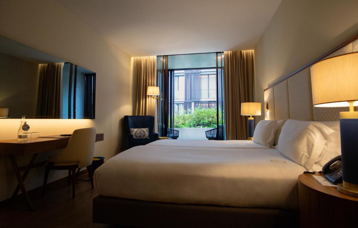 Uma cama ou camas num quarto em Boeira Garden Hotel Porto Gaia, Curio Collection by Hilton