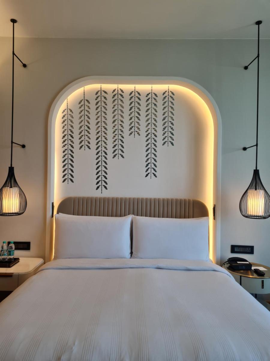 a bedroom with a large white bed with two lights at InterContinental Jaipur Tonk Road by IHG in Jaipur