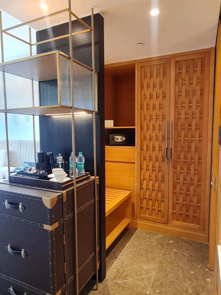 a kitchen with wooden cabinets and a shelf at InterContinental Jaipur Tonk Road by IHG in Jaipur