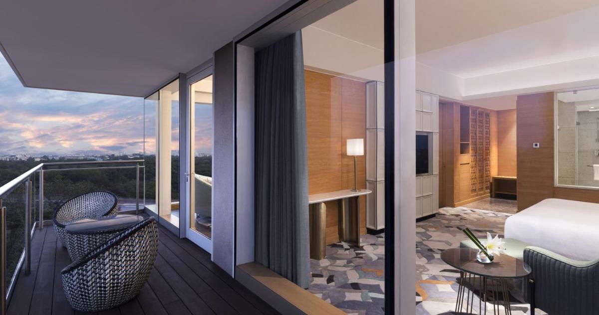 a hotel room with a balcony with a bed and a table at InterContinental Jaipur Tonk Road by IHG in Jaipur