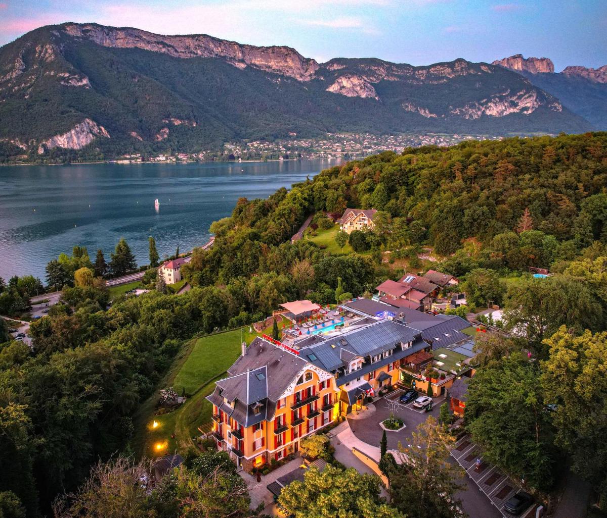- une vue aérienne sur un hôtel avec un lac et des montagnes dans l'établissement Les Trésoms Lake and Spa Resort, à Annecy
