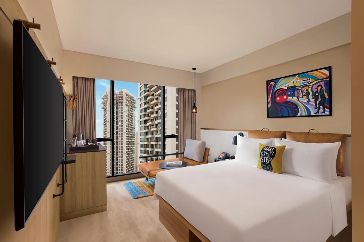 a hotel room with a bed and a tv at Moxy Mumbai Andheri West in Mumbai