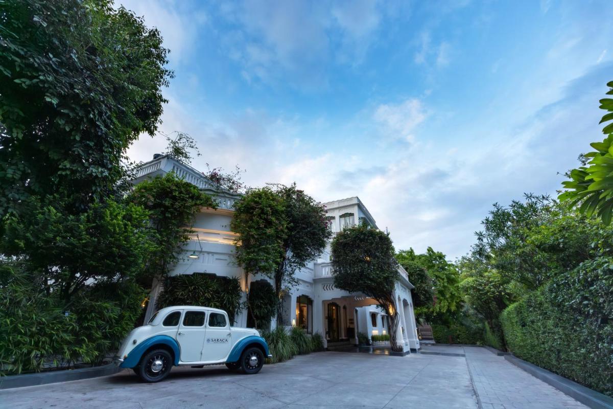 an old white car parked in front of a house at Saraca Hotel Lucknow in Lucknow