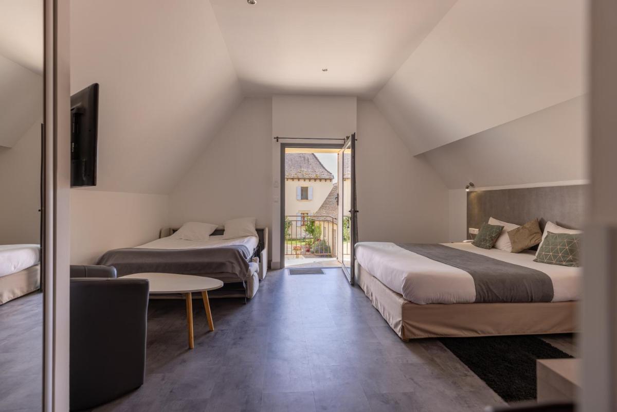 une chambre avec deux lits, une table et une fenêtre dans l'établissement Logis Hotel Archambeau, à Thonac