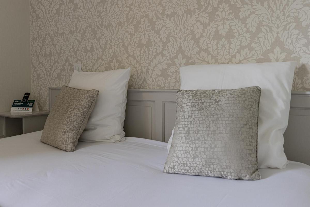 Un ou plusieurs lits dans un hébergement de l'établissement Logis Hotel Archambeau