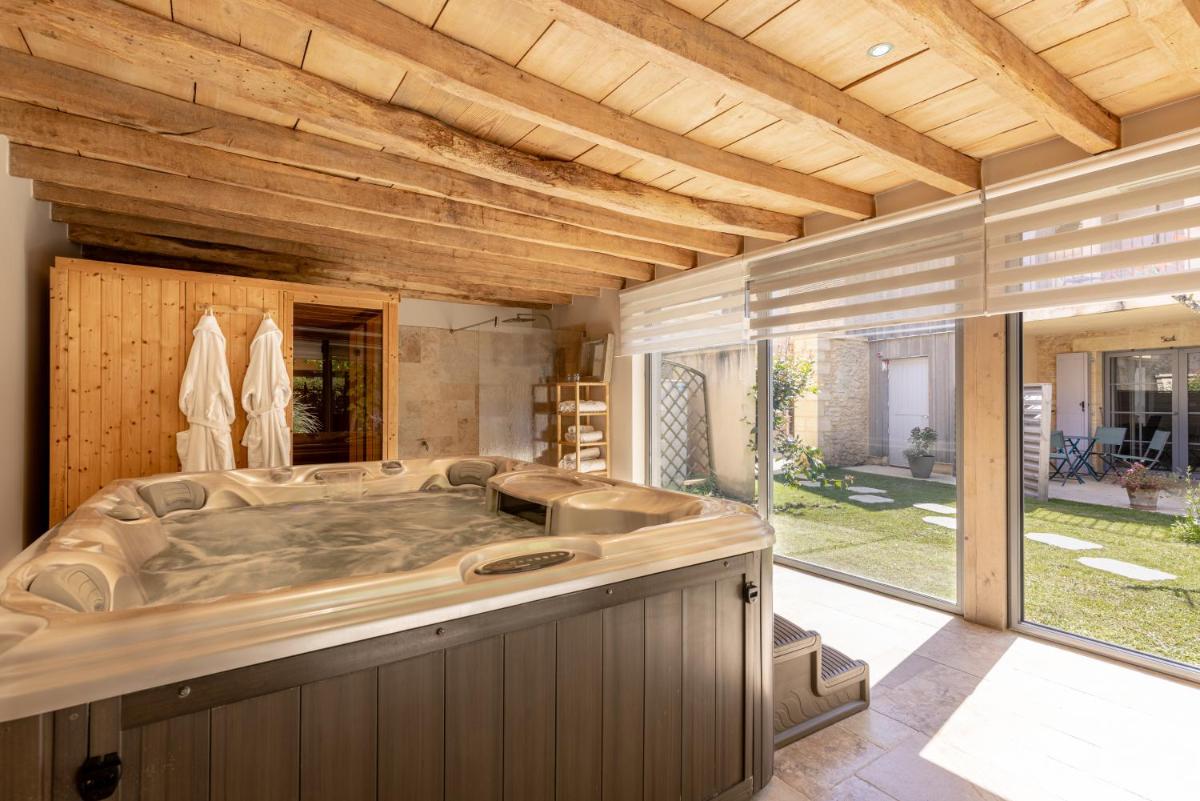 - une grande salle de bains avec baignoire au milieu dans l'établissement Logis Hotel Archambeau, à Thonac