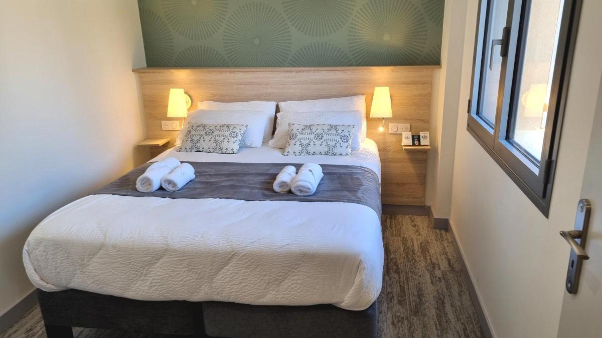 Un ou plusieurs lits dans un hébergement de l'établissement Logis Hotel Archambeau