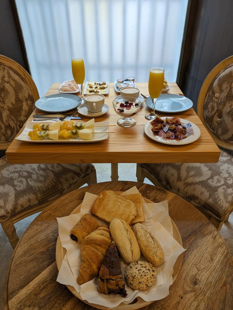 una mesa con platos de comida y vasos de jugo de naranja en Akla Hotel Mérida, en Mérida