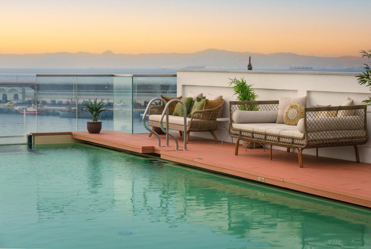 Una terraza con sillas y una piscina en un edificio. en La Residencia Puerto Hotel & Spa, en Tarifa