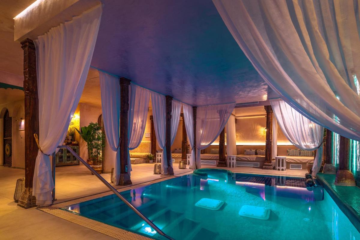 una piscina en una casa con cortinas en La Residencia Puerto Hotel & Spa, en Tarifa