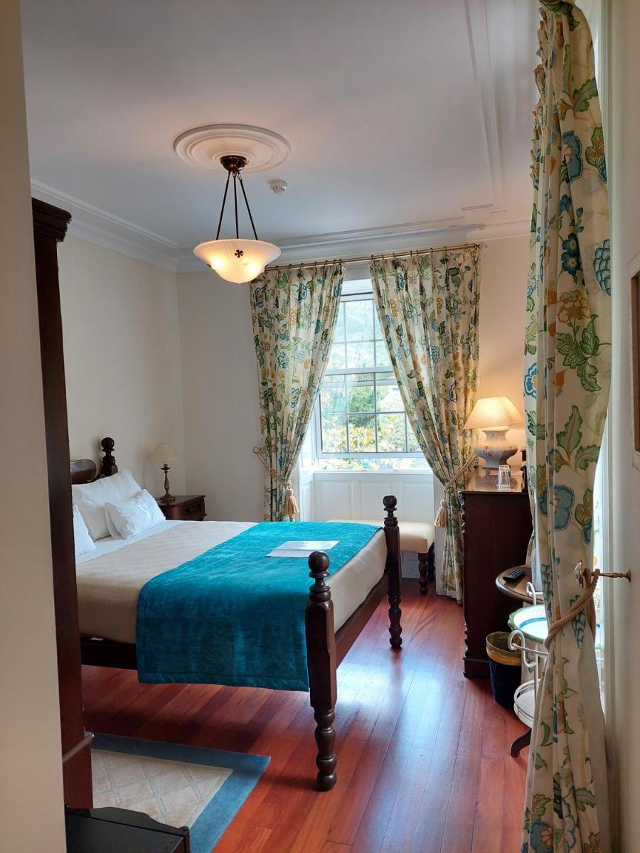 um quarto com uma cama e uma janela grande em Estalagem do Vale em São Vicente