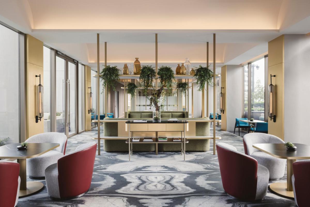 a lobby of a hotel with tables and chairs at Pan Pacific Orchard in Singapore