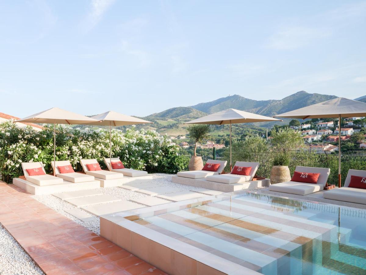 un patio avec des chaises longues blanches et une piscine dans l'établissement Maison Nova - Boutique Hôtel & Spa, à Collioure