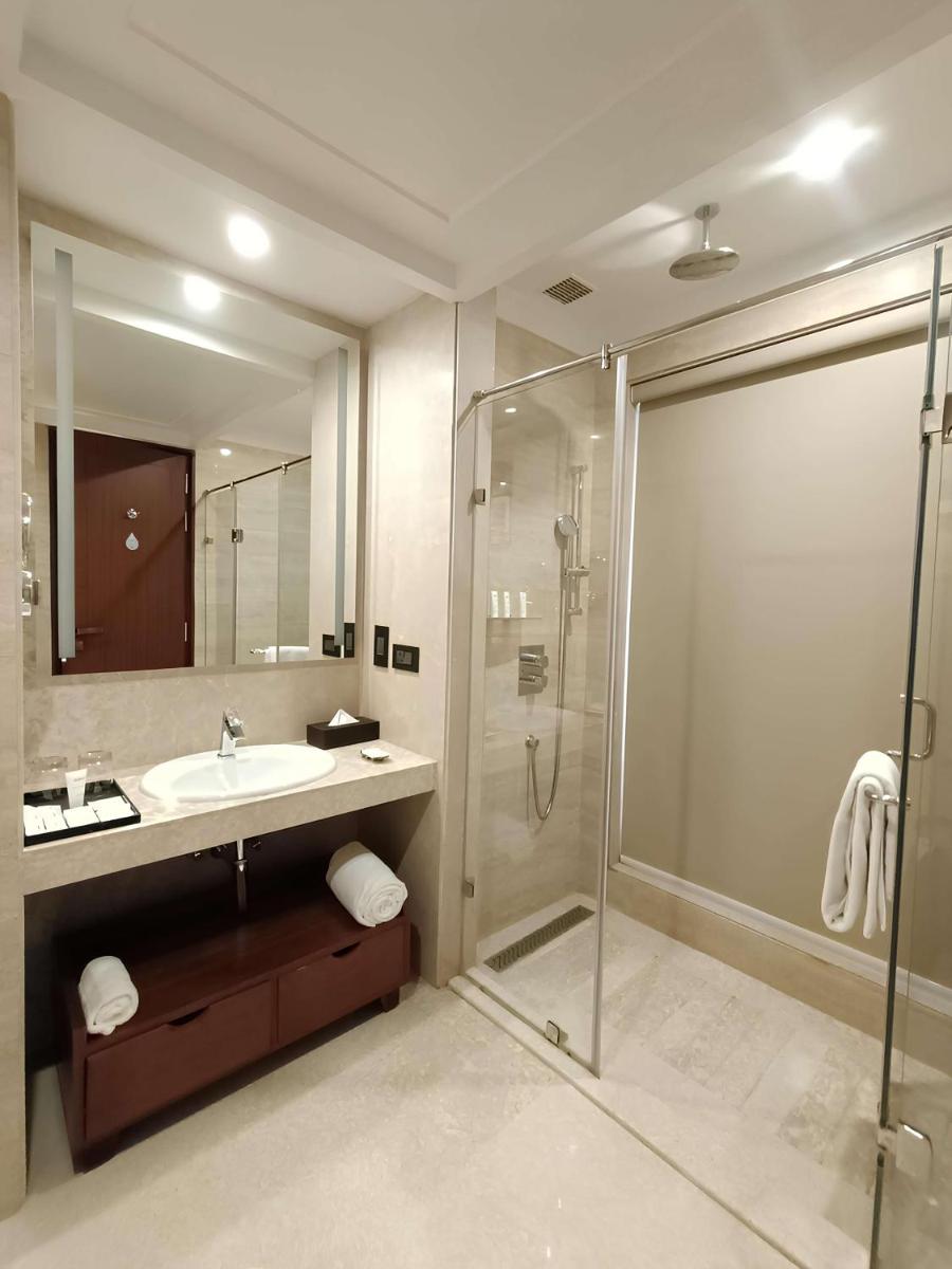 a bathroom with a glass shower and a sink at Radisson Kufri in Shimla