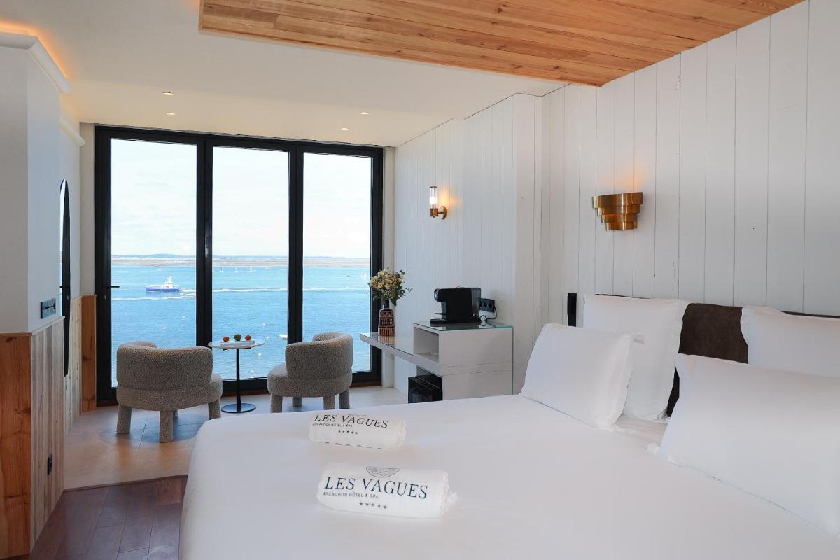 une chambre avec un lit et une vue sur l'océan dans l'établissement Les Vagues Hotel & Spa, à Arcachon