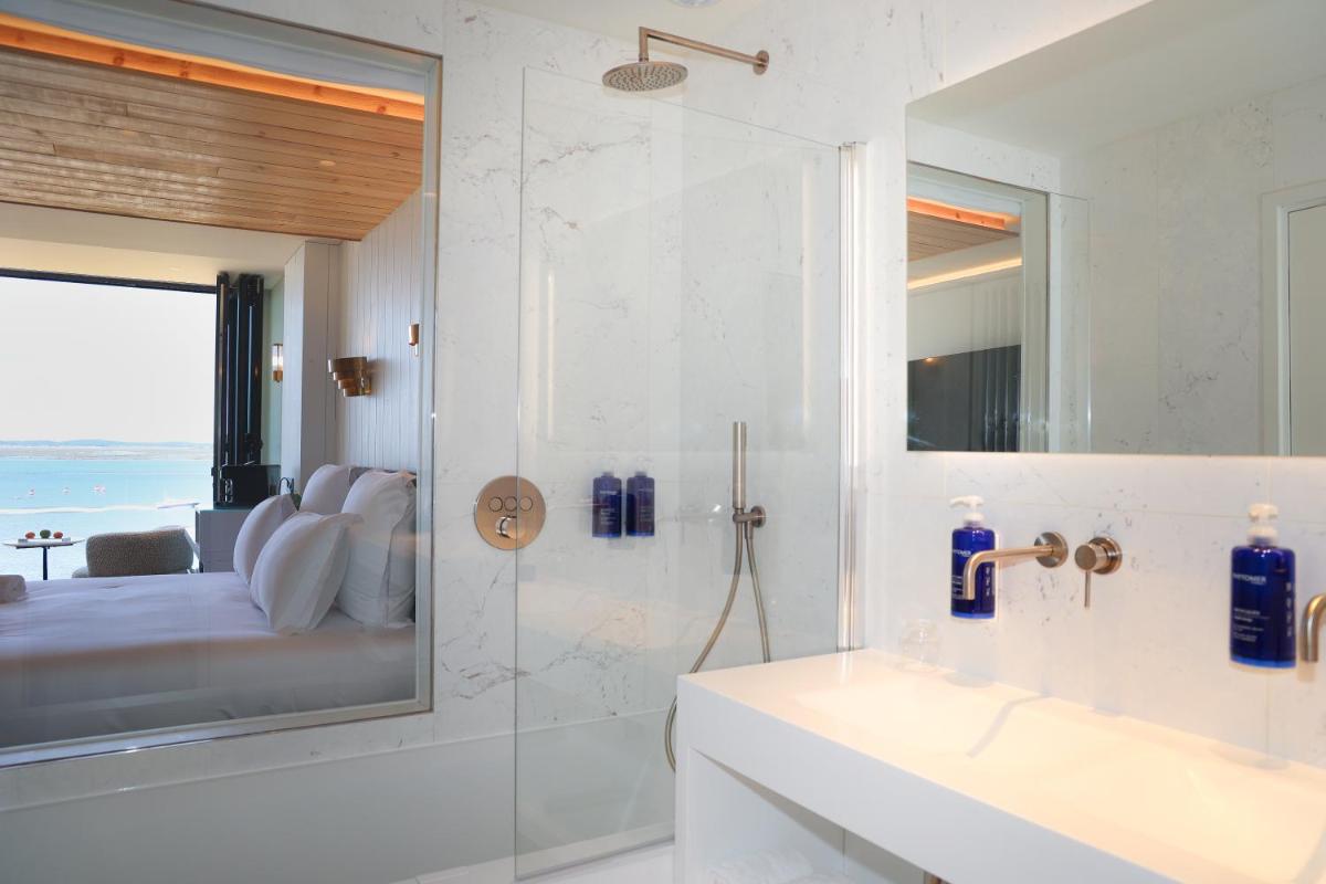 une salle de bain avec une douche, un lavabo et un miroir dans l'établissement Les Vagues Hotel & Spa, à Arcachon