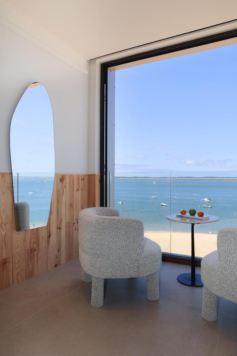 - une chambre avec deux chaises et une table offrant une vue sur l'océan dans l'établissement Les Vagues Hotel & Spa, à Arcachon