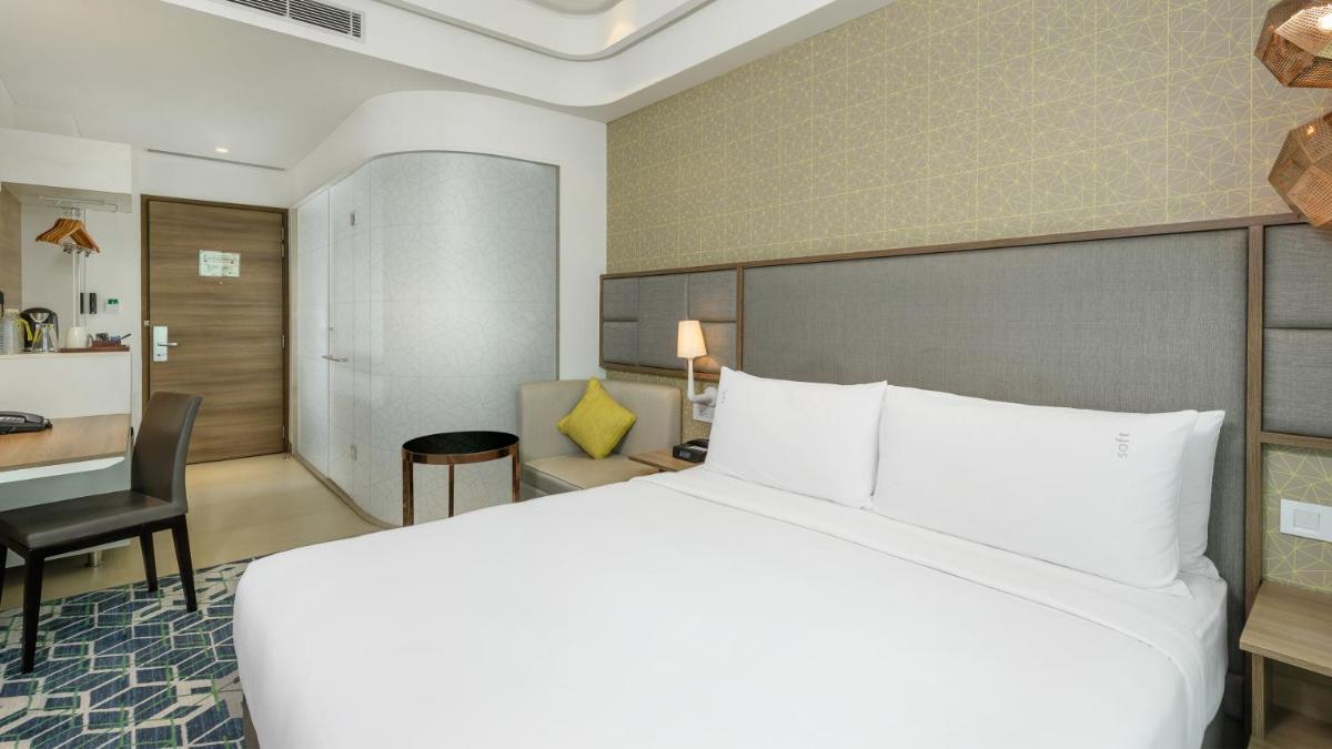 a hotel room with a large bed and a desk at Holiday Inn Gurugram Sector 90 by IHG in Gurgaon