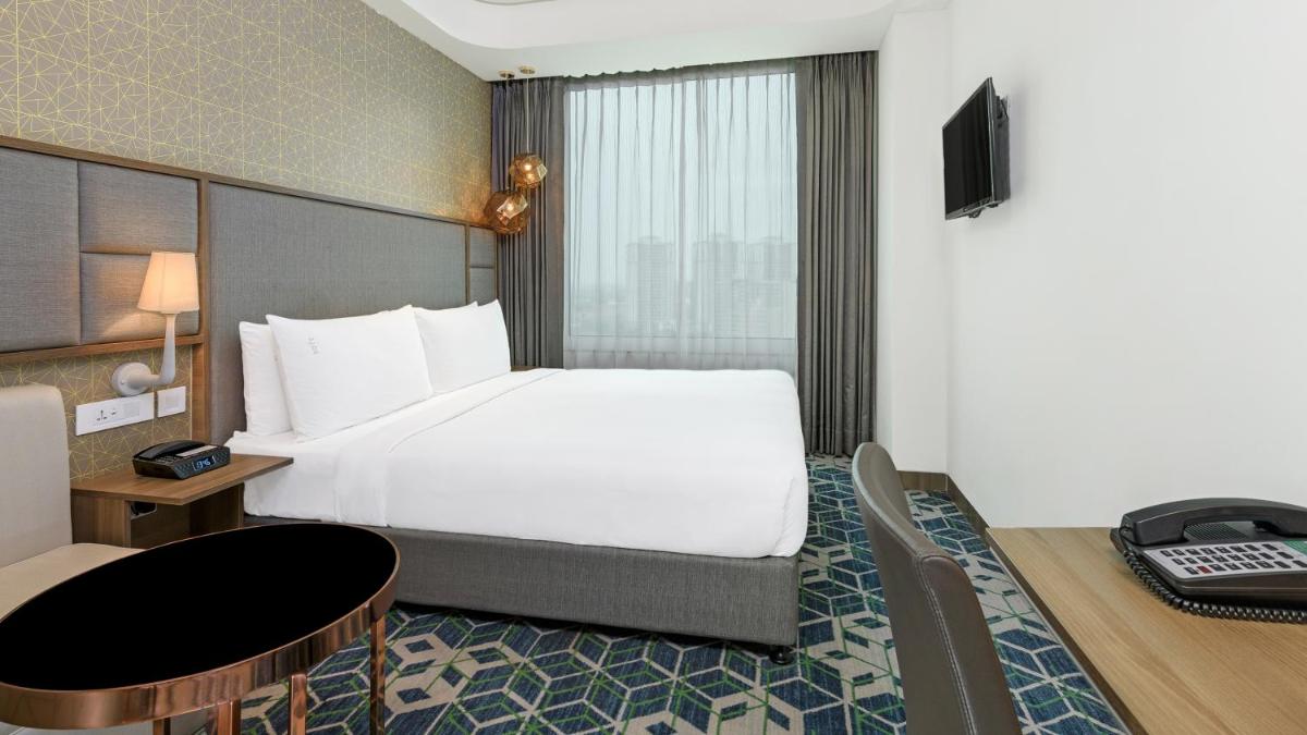 a hotel room with a large bed and a desk at Holiday Inn Gurugram Sector 90 by IHG in Gurgaon