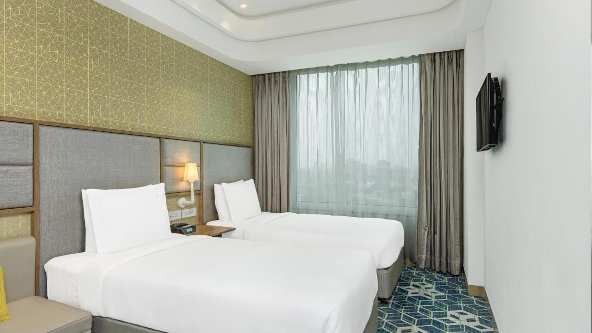 a hotel room with two beds and a window at Holiday Inn Gurugram Sector 90 by IHG in Gurgaon