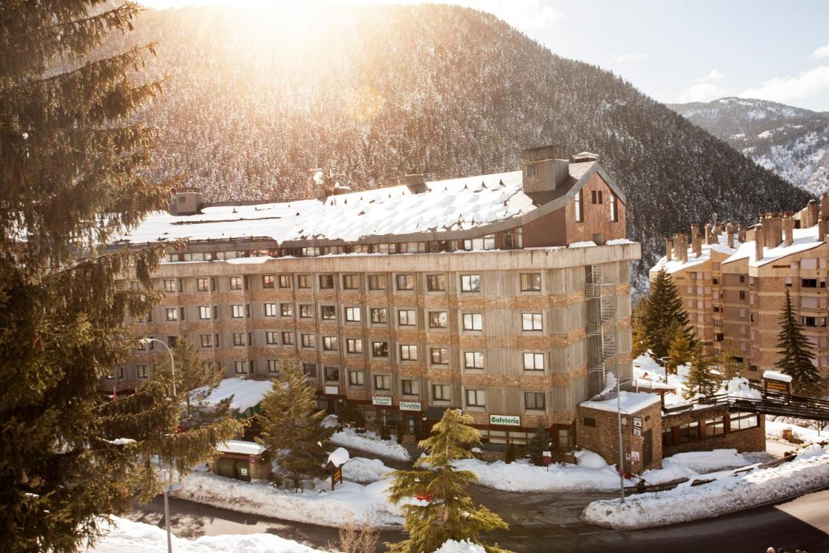 un edificio en la nieve con una montaña en el fondo en Tuc Blanc, en Baqueira Beret