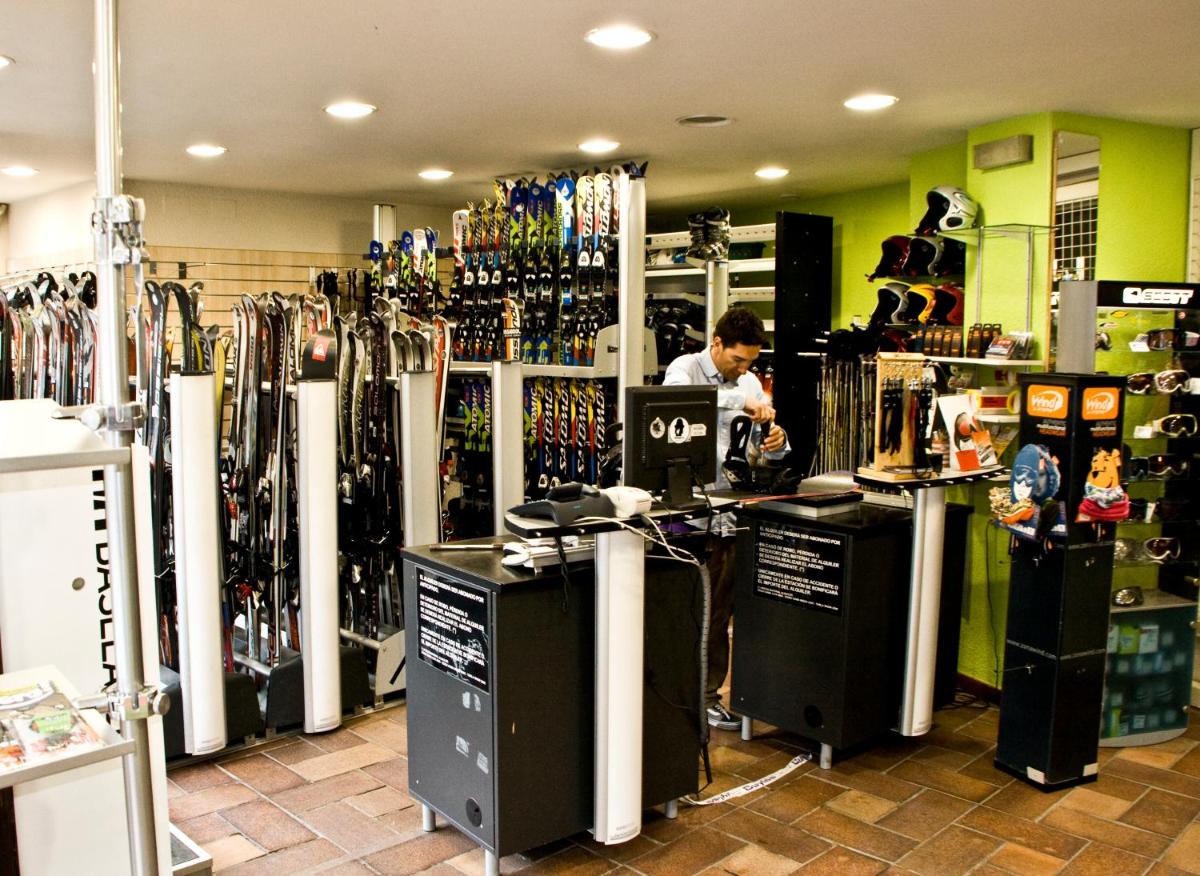 un hombre parado en un mostrador en una tienda con un montón de botellas en Tuc Blanc, en Baqueira Beret
