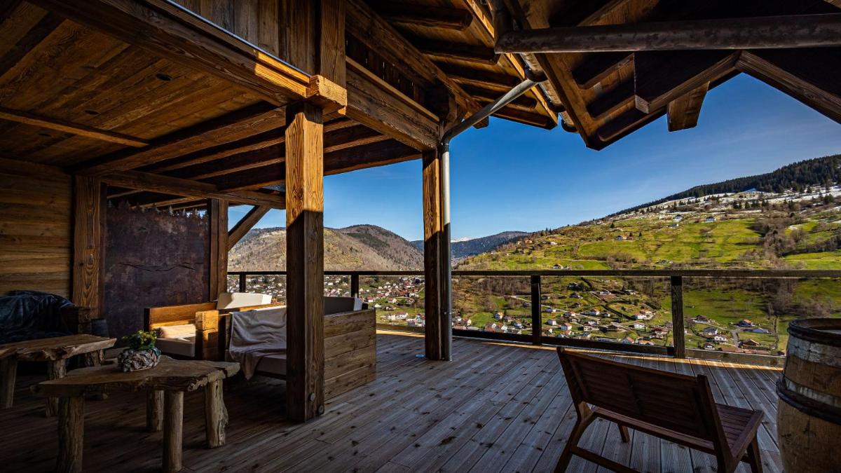 une véranda en bois avec vue sur une montagne dans l'établissement LA CABANE DU BREUIL, à La Bresse