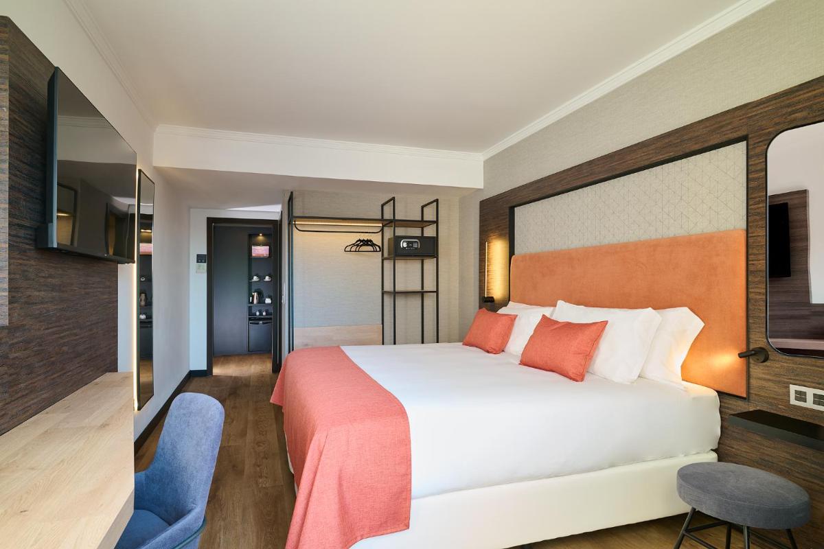 una habitación de hotel con una cama y una silla en Gran Hotel Luna de Granada, en Granada