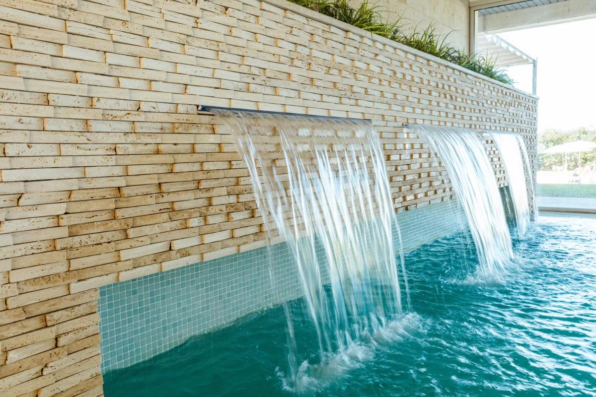 Una fuente de agua en una pared de ladrillos con cascadas. en Seth 55 Santo Tomas, en Santo Tomás