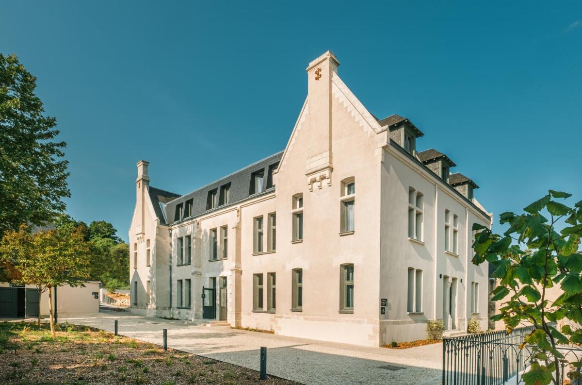 un grand bâtiment blanc avec deux tours dans l'établissement La Maison Rabelais, à Amboise