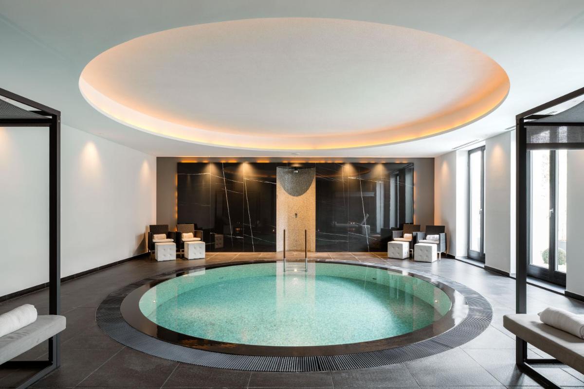ein großer Pool mitten in einem Raum mit einer Decke in der Unterkunft A-ROSA Hotel Ceres am Meer - Adults Only in Binz